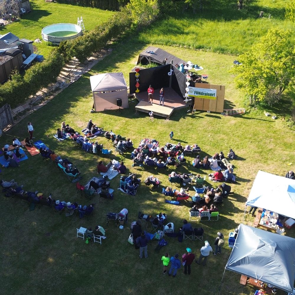 Aerial view of the community watching a performance on the school lawn